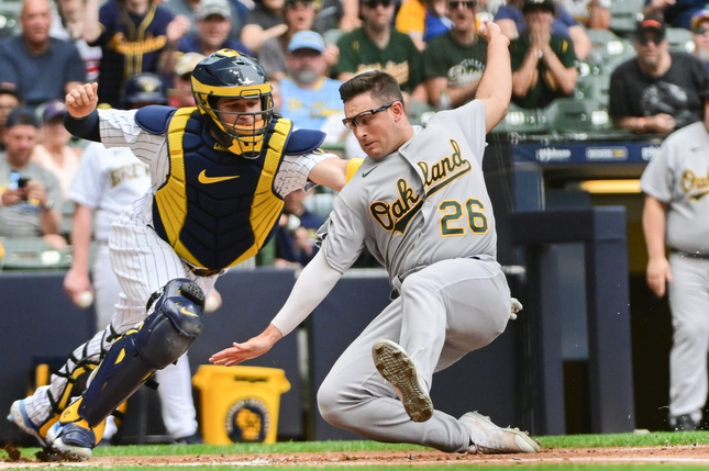 Jun 10, 2023; Milwaukee, WI, USA; Milwaukee Brewers catcher Victor Carlatini (7) knocks off Oakland Athletics third base in the second inning at Home Field hand Jonah Blade (26).